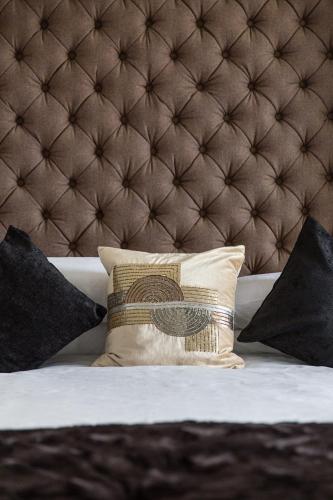 a bed with a brown headboard and a pillow on it at Kildonan Guest House in Aberdeen