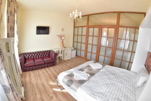 a bedroom with a bed and a red couch at La Maisonnette in Braşov