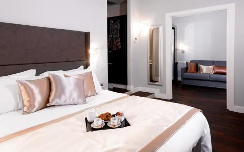 - une chambre d'hôtel avec un lit et un plateau de nourriture dans l'établissement Piazza di Spagna Suite de Charme, à Rome