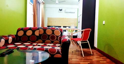 a living room with a couch and a glass table at Finimas Residence in Thimarafushi
