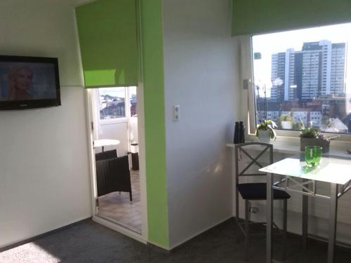 a room with green walls and a table and a window at Deichstern in Bremerhaven