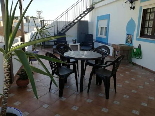 eine Terrasse mit einem Tisch und Stühlen auf dem Balkon in der Unterkunft Atico SIROCO in Sanlúcar de Barrameda