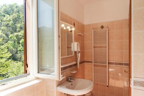 Martina Olba的住宿－Albergo Minetto，一间带水槽和窗户的浴室