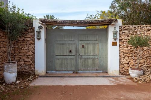 a green garage door with a stone wall at Dar Al Manar in El Jadida