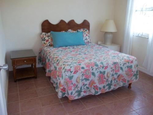 a bedroom with a bed with a floral bedspread at Ocean Ridge at Long Beach in Christ Church