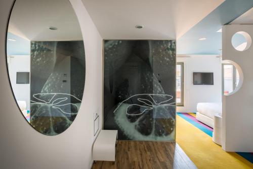 a room with a mirror and a bed at Room Mate Pau, Barcelona in Barcelona