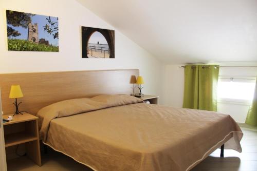 カステッランマーレ・デル・ゴルフォにあるBorgo Aranci - Villetta Peonia B3 - Castellammare del Golfoのベッドルーム1室(ベッド1台、テーブル2台、窓付)