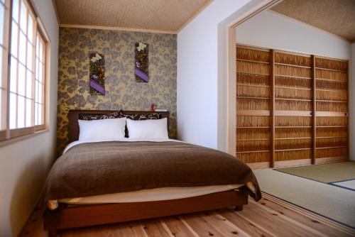 a bedroom with a bed in a room with book shelves at 色絵古都 IROEKOTO in Kyoto