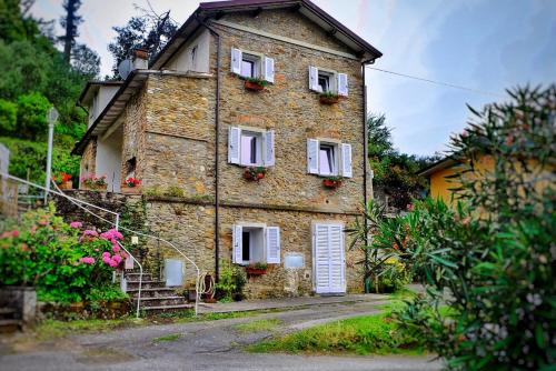 una antigua casa de ladrillo con ventanas blancas y flores en Pietrasanta en Pietrasanta