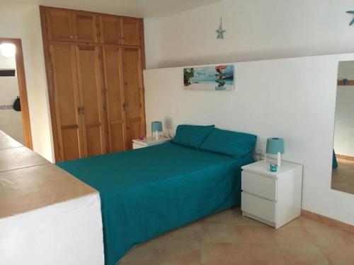 ein Schlafzimmer mit einem blauen Bett und einer Holztür in der Unterkunft apartamento pueblo rocio 80 in Nerja