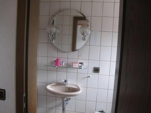 ein Bad mit einem Waschbecken und einem Spiegel in der Unterkunft Gasthaus Zum Rothenberg in Lemberg