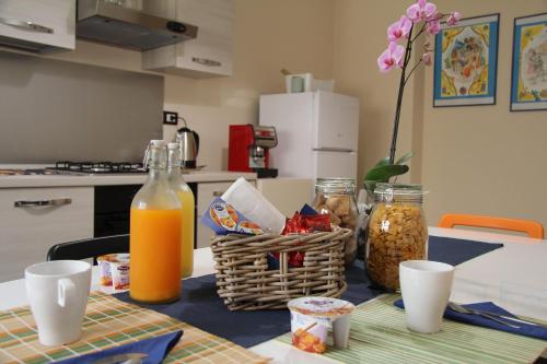 un tavolo con un cesto di cibo e succo d'arancia di Urban Pop Bnb a Catania