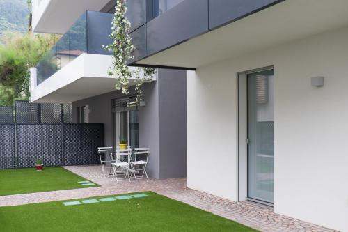 an internal courtyard of a house with green grass at Hotel Garnì Villa Maria in Riva del Garda