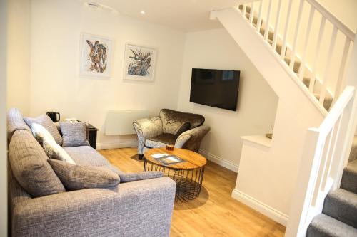 a living room with two couches and a tv at Latimer House in Bowness-on-Windermere