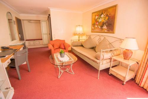 a living room with a couch and a table at Ringhotel Alpenhof - Patchworkhotel in Augsburg