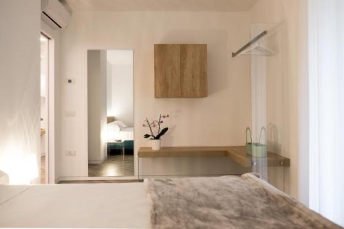 Habitación con cocina con cama y espejo. en Hotel Garnì Villa Maria, en Riva del Garda