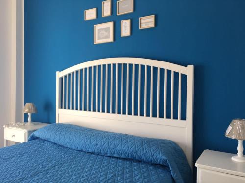 a blue bedroom with a bed and a blue wall at Blue Sky Apartments in Capo dʼOrlando