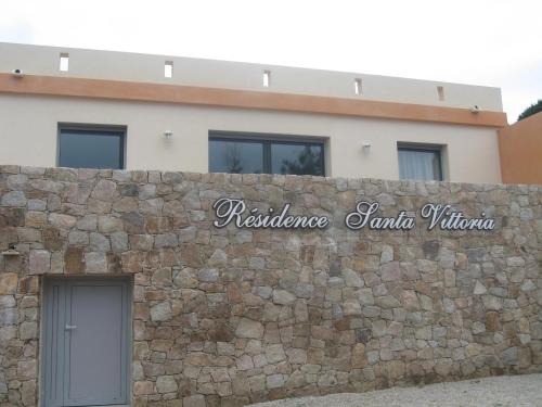 a stone wall in front of a building at Residences Santa Vittoria in Algajola