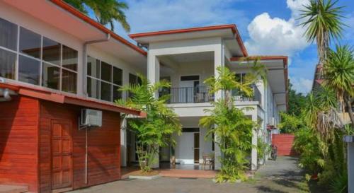 a house with palm trees in front of it at Mathurin Appartementen in Paramaribo