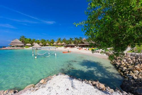 a beach with a bunch of people in the water at Hotel Punta Faro in Isla Mucura