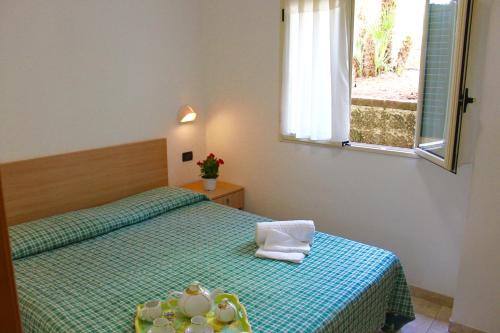 ein Schlafzimmer mit zwei Betten und einem Fenster in der Unterkunft Villaggio Turistico Defensola in Vieste