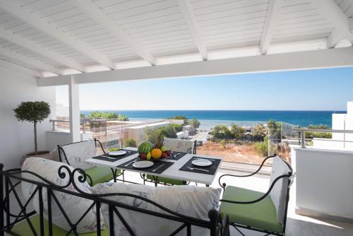 a patio with a table with a view of the ocean at Coral Apartments in Ierapetra