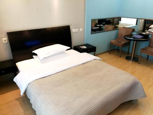 um quarto com uma grande cama branca e uma mesa em Xinshikong Apartments- Abest Zhongshan Park No.1 em Xangai