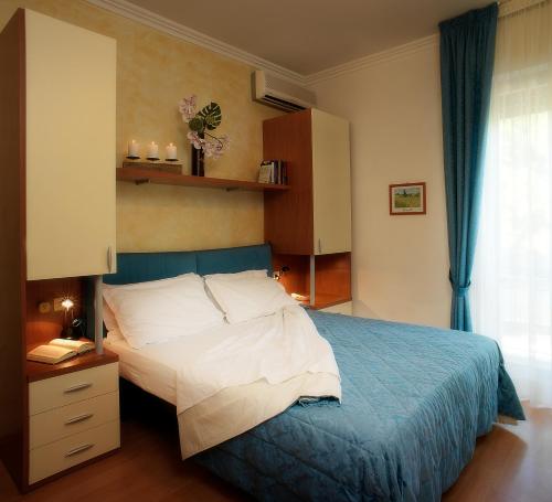 a bedroom with a bed with a blue comforter at Hotel Hawaii in Riccione