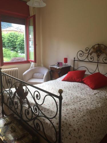 ein Schlafzimmer mit einem Bett, einem Stuhl und einem Fenster in der Unterkunft B&B Il tempo del sogno con cani e gatti Pet&Breakfast in Baveno