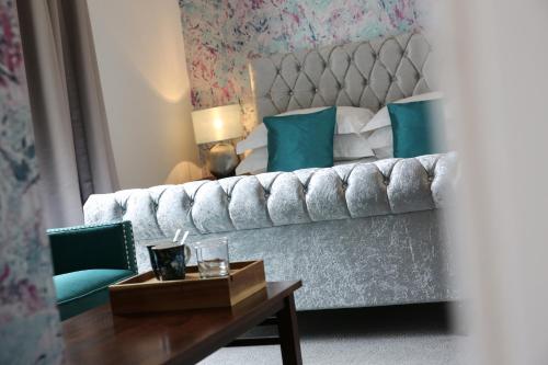 a bedroom with a couch and a table and a bed at Latimer House in Bowness-on-Windermere