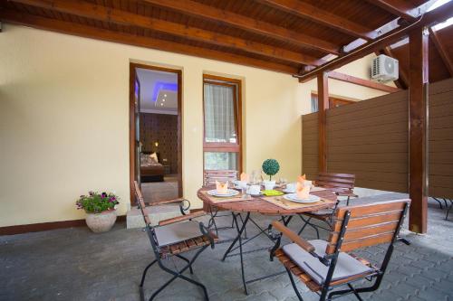 un patio con mesa de madera y sillas en Balaton Kinizsi Apartman en Siófok