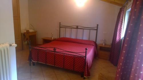 a bedroom with a red bed in a room at Locanda Nonno Puin in Ferrada di Moconesi