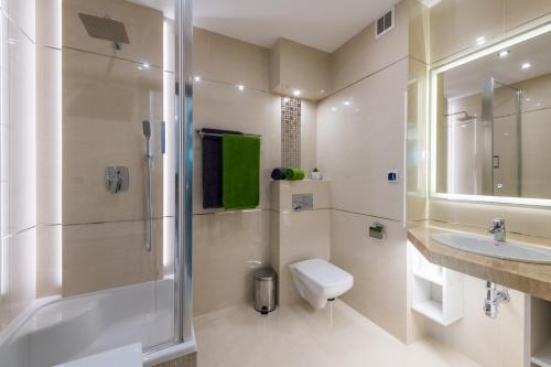 La salle de bains est pourvue d'une douche, de toilettes et d'un lavabo. dans l'établissement Apartament Marina View, à Giżycko