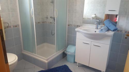 a bathroom with a shower and a sink and a toilet at Apartman Rab Blue in Rab