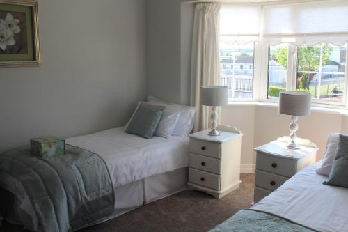 a bedroom with two beds and a window at 5 mins walk to Carrick - Sleeps 12 - Off road parking - Modern house in Carrick on Shannon