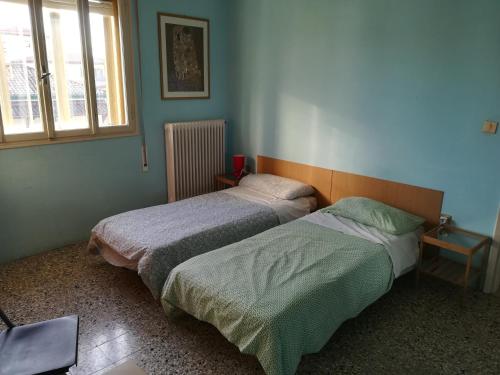2 łóżka w sypialni z oknem w obiekcie Venice Lagoon House B&B w mieście Tessera