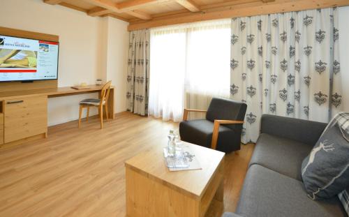 a living room with a couch and a table at Hotel Residenz Hochland in Seefeld in Tirol