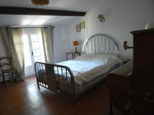une chambre avec un lit dans une pièce avec une fenêtre dans l'établissement aile d'un ancien mas, à La Roque-dʼAnthéron