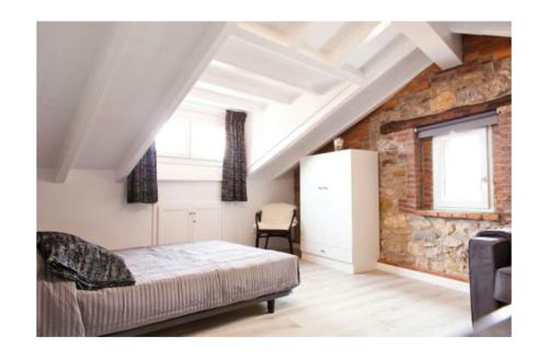 a bedroom with a bed and a brick wall at LOFT Centro Ribadesella in Ribadesella