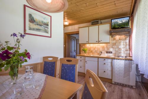 a kitchen with a table and chairs and a dining room at otto steiner appartements pension ellmau & wilder kaiser in Ellmau