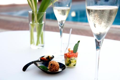 una mesa con un plato de comida y copas de champán en Fiordaliso Hotel, en San Felice Circeo