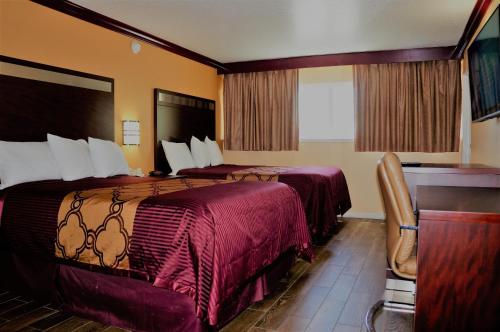 a hotel room with two beds and a desk at Americas Deluxe Inn- Marysville in Marysville