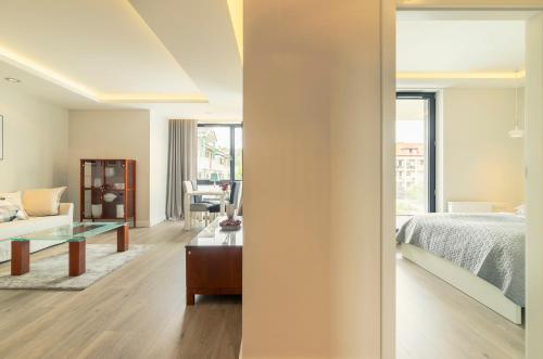 ソポトにあるLuxury Apartments - Okrzei Residence by Grand Apartmentsのベッドルーム1室(ベッド1台付)、リビングルームが備わります。