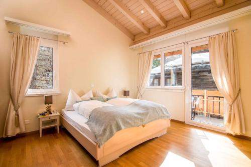 1 dormitorio con 1 cama en una habitación con ventanas en Chalet Sunshine, en Saas-Fee