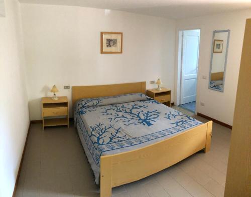 een slaapkamer met een bed en twee nachtkastjes bij MARIA'S HOUSE in Porto Pino