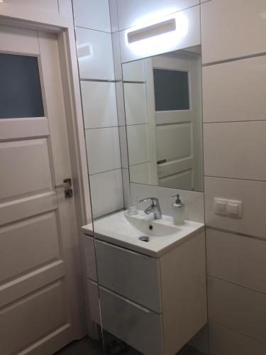 a bathroom with a sink and a mirror at Baltic Apartament z basenem zewnętrznym ul Marynarska 4, Sarbinowo in Sarbinowo