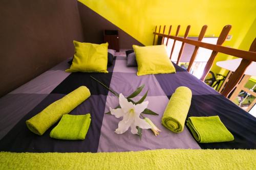 ブダペストにあるGreen Apartment Budapestの緑の枕と花が付いたベッド