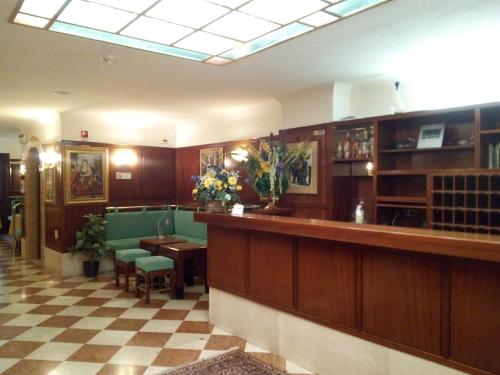 a waiting room with a bar and a table and chairs at Hotel Diana in Venice
