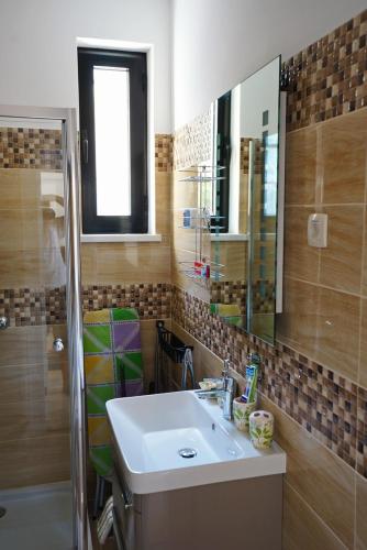 a bathroom with a sink and a mirror and a shower at Apartments FANTASY in Kotor