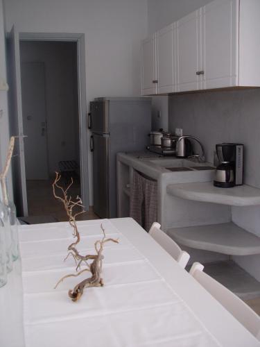 a kitchen with a table with a white table cloth at Litsa Malli Rooms in Pollonia